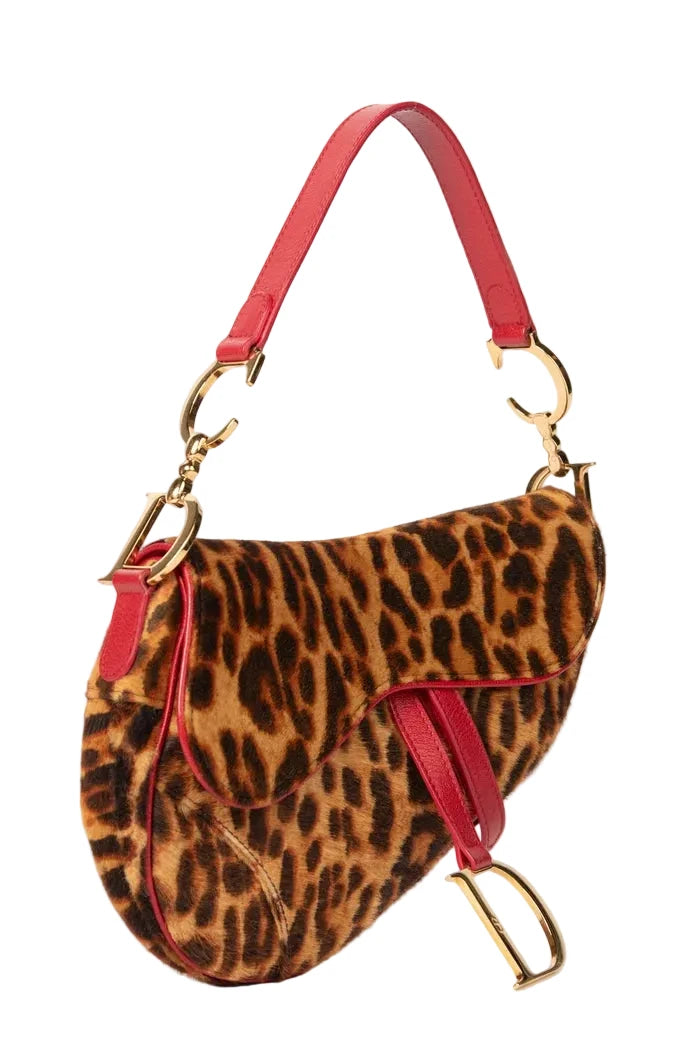 Leopard print handbag with red straps and gold hardware on a white background