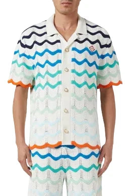 Person wearing a colorful knitted shirt with a white background