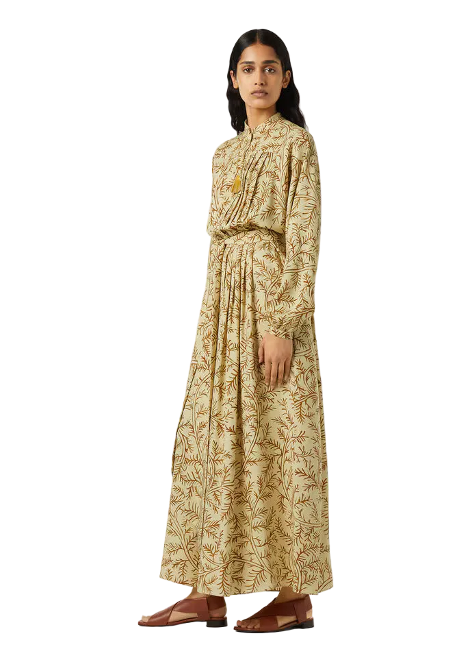 Woman wearing a long, patterned dress on a white background