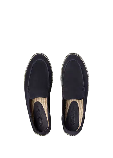 Pair of black espadrille shoes on a light beige background