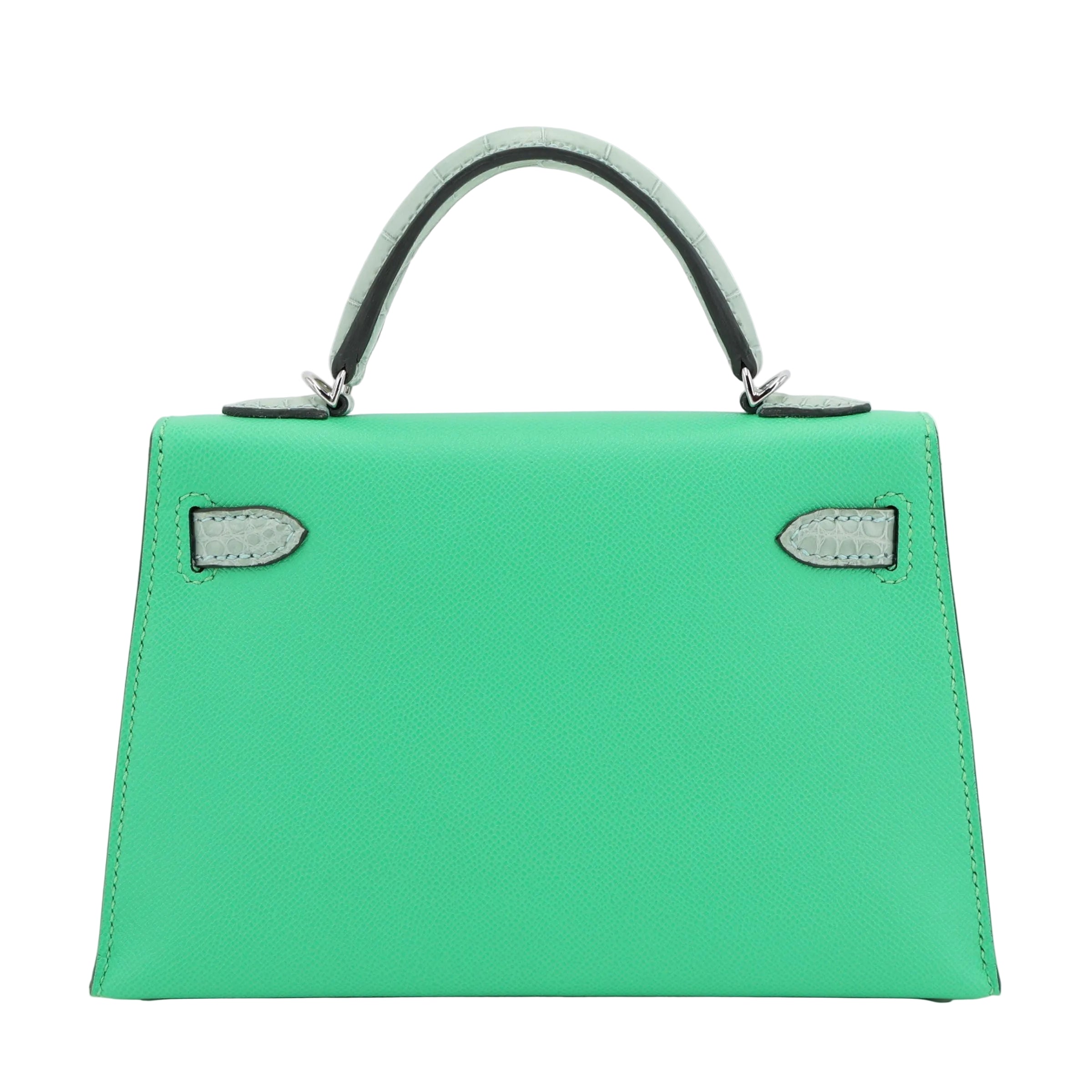 Green handbag with black handle on a light gray background