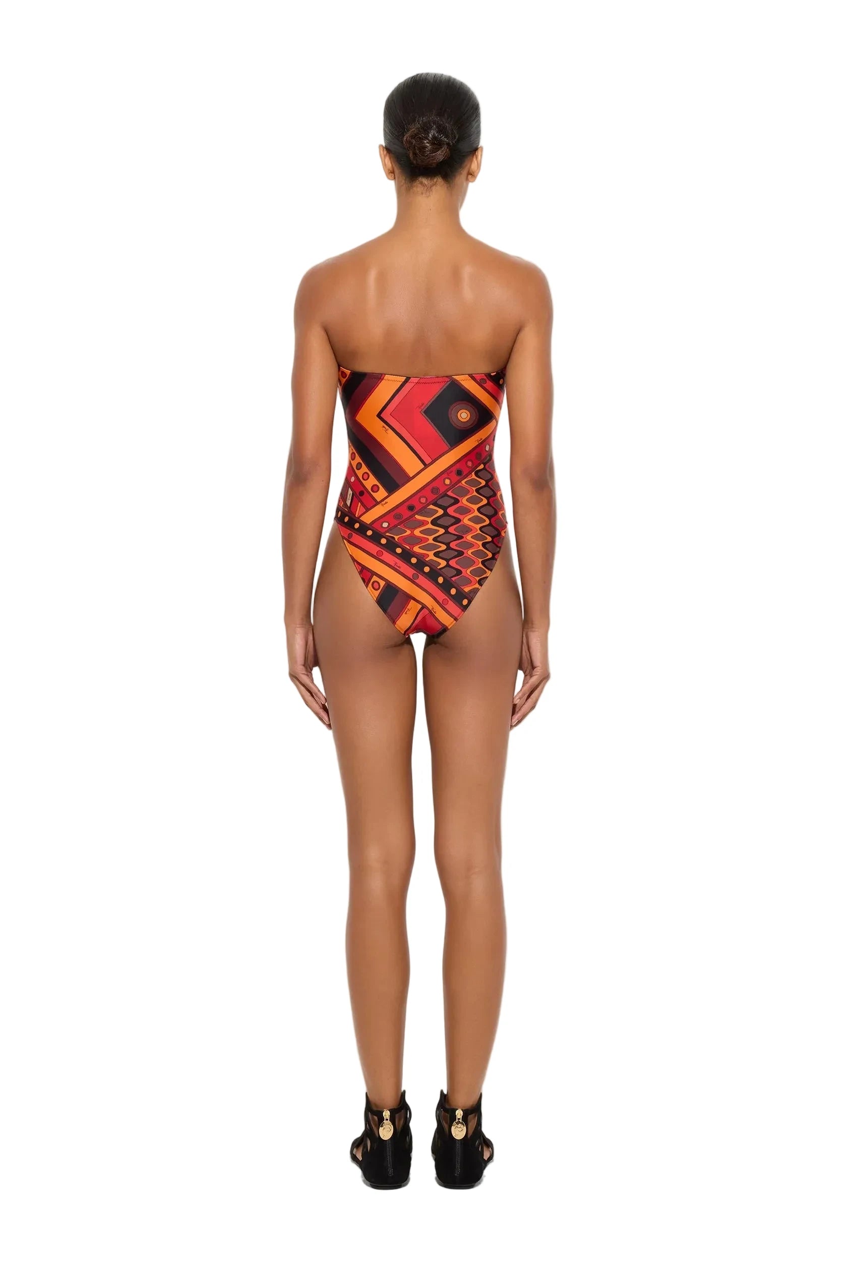 Woman wearing a strapless, patterned swimsuit on a white background