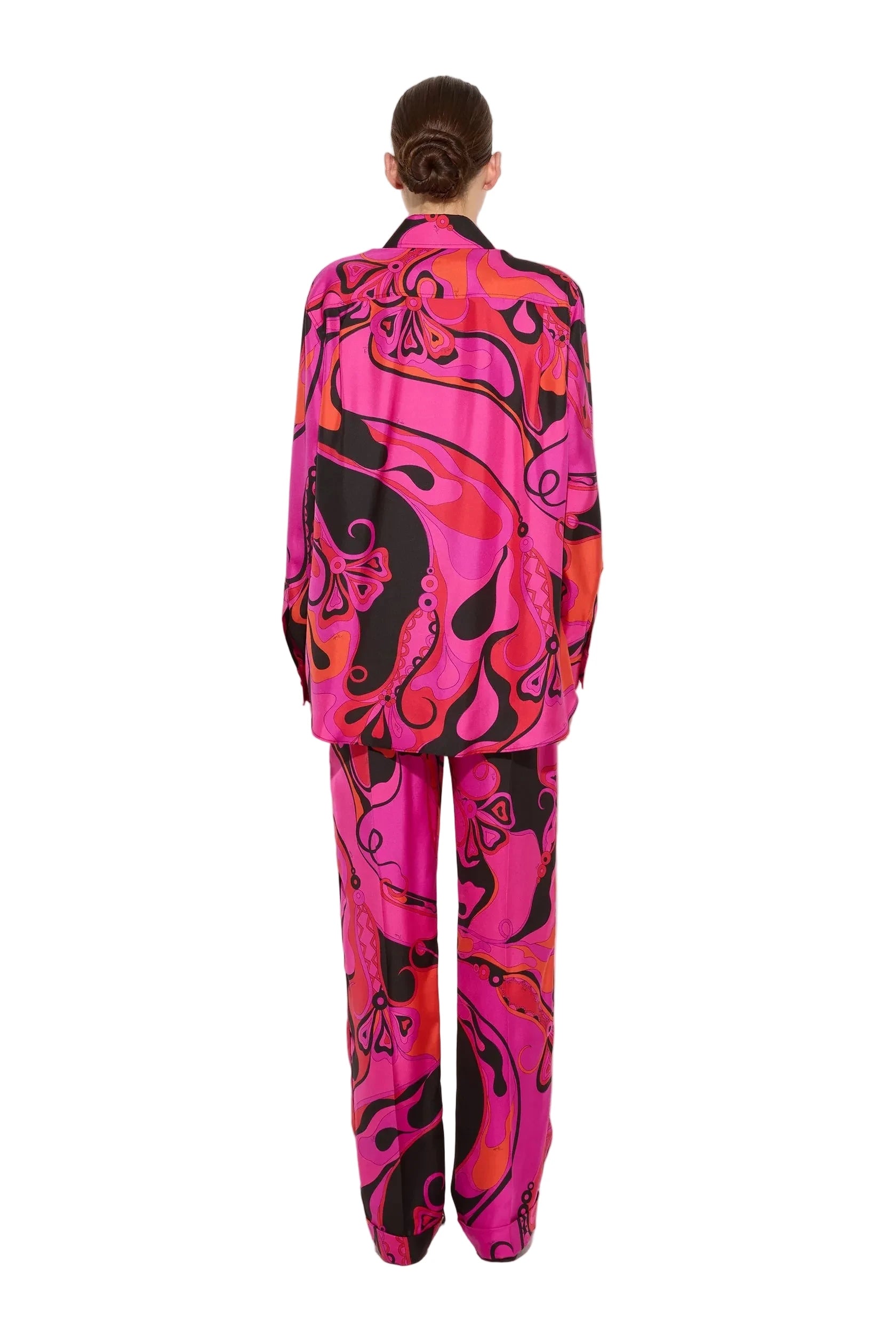 Person wearing a vibrant pink and black patterned suit on a white background