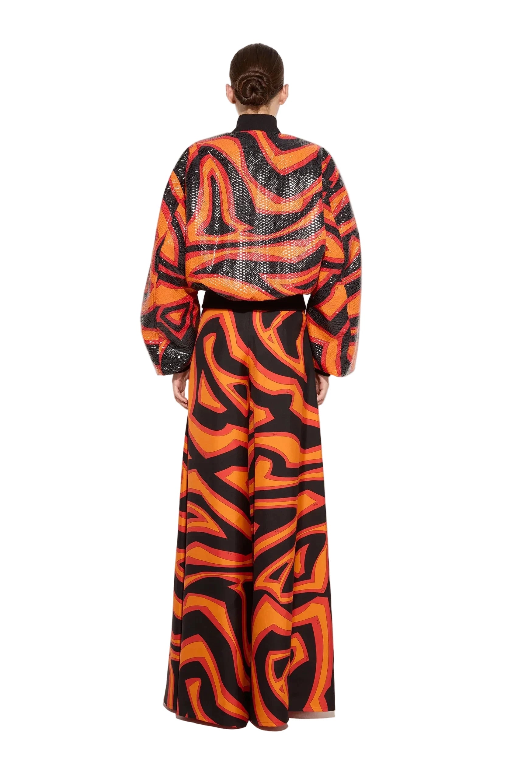 Person wearing a vibrant orange and black patterned outfit on a white background
