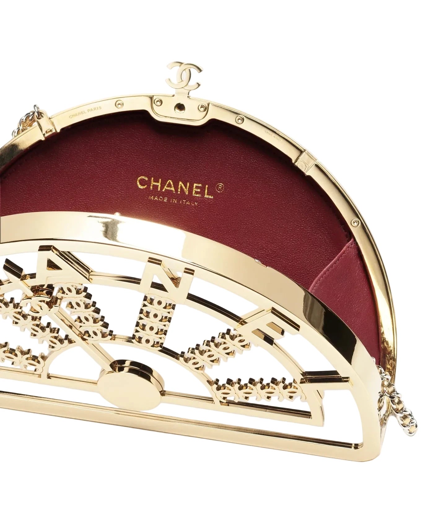 Chanel gold clutch with intricate design on a white background