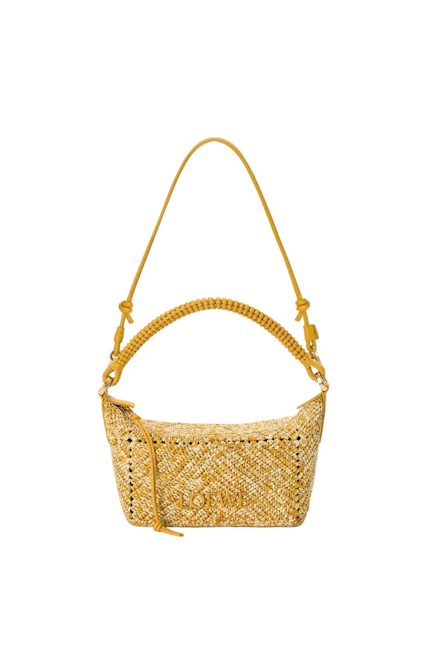 Yellow woven handbag with a strap on a white background
