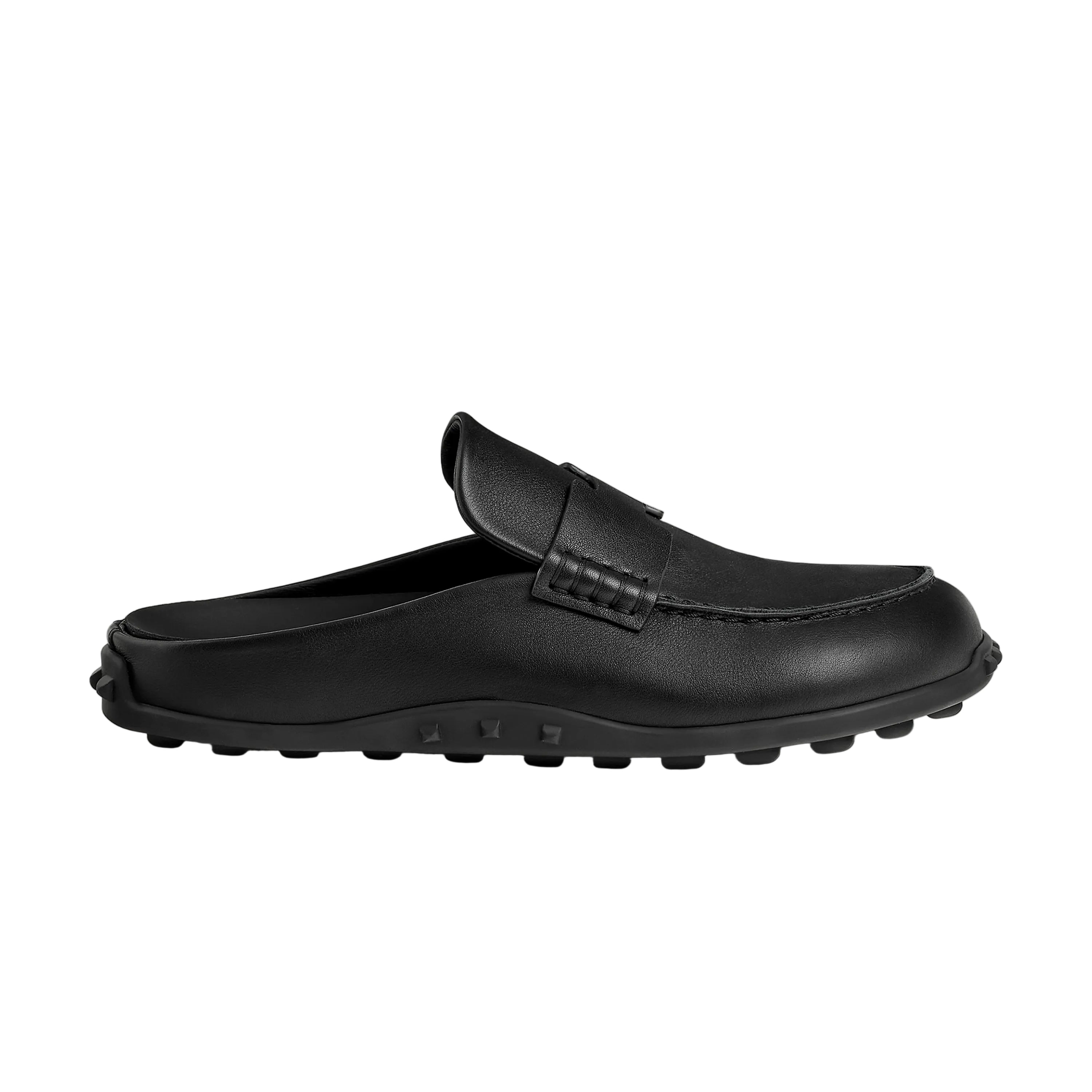 Black slip-on shoe on a beige background