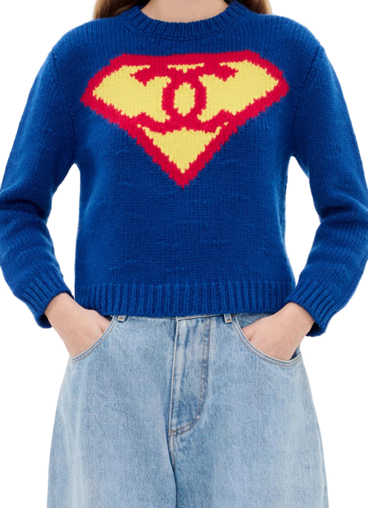 Person wearing a blue sweater with a Superman logo design on a white background