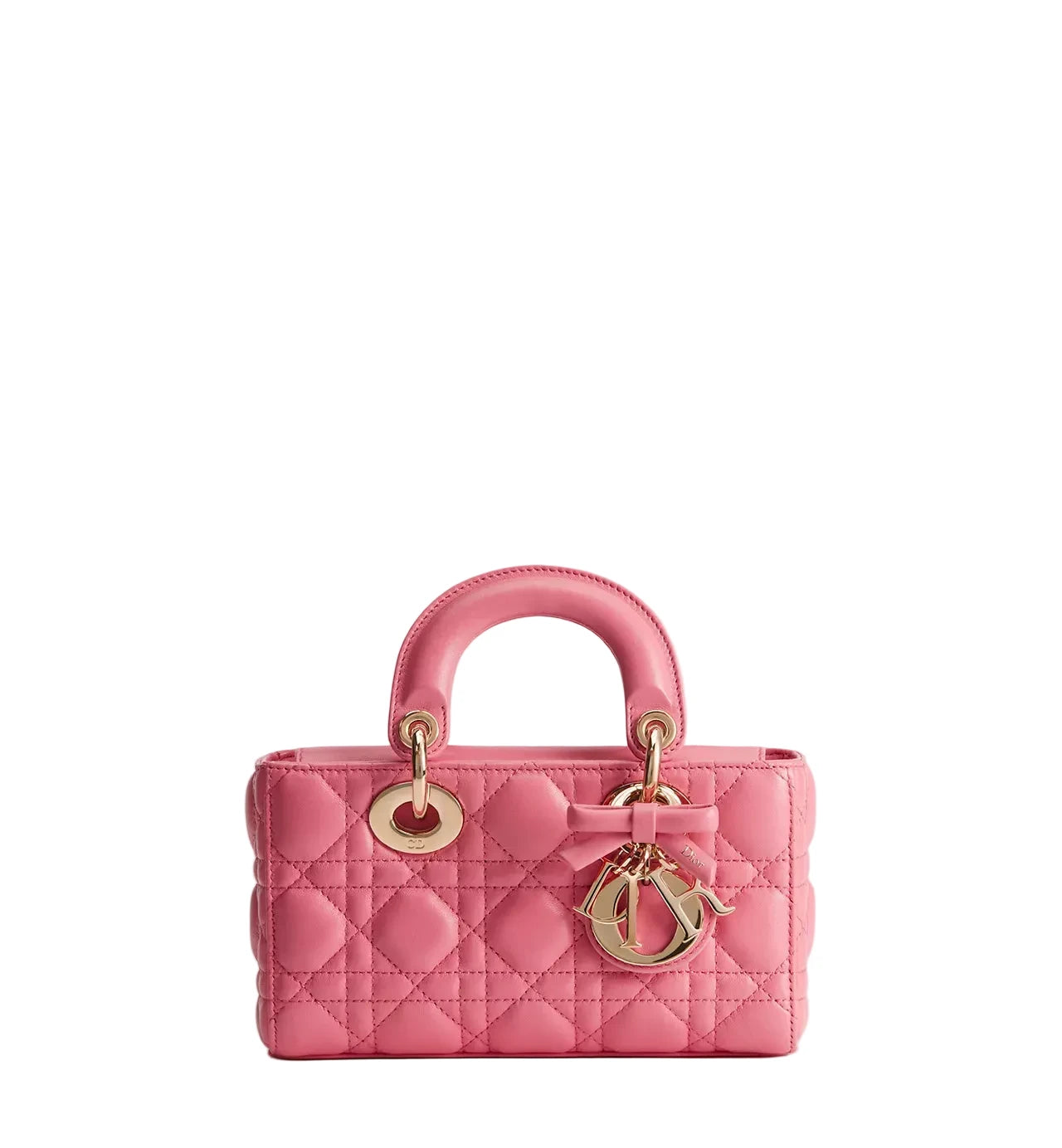 A pink quilted leather top-handle handbag with gold-tone hardware, including a bow detail and a hanging CD charm, photographed against a clean white background.