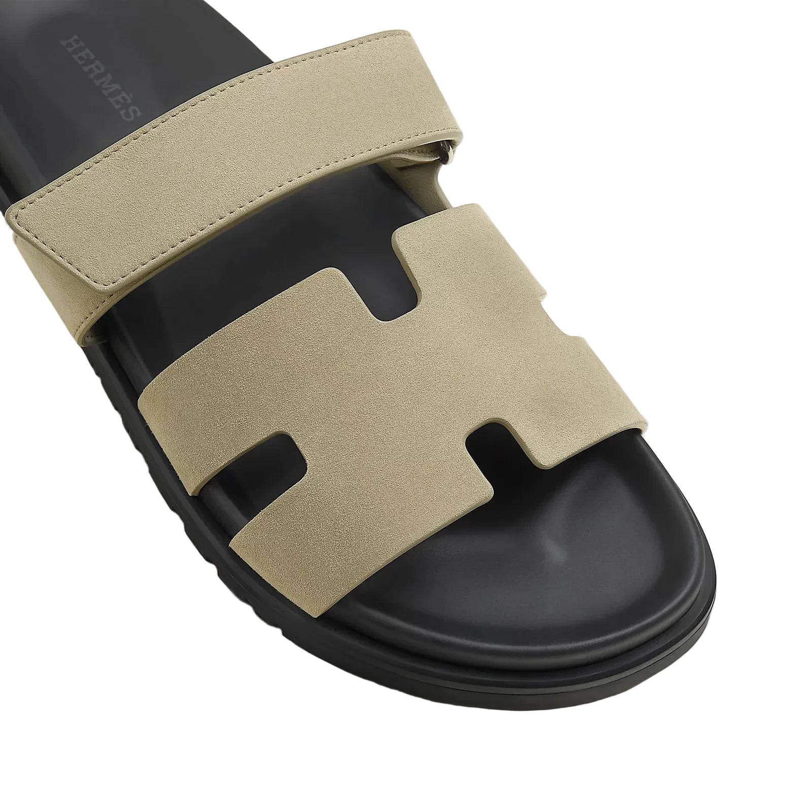 Beige and black sandal with a prominent 'H' logo on a light background