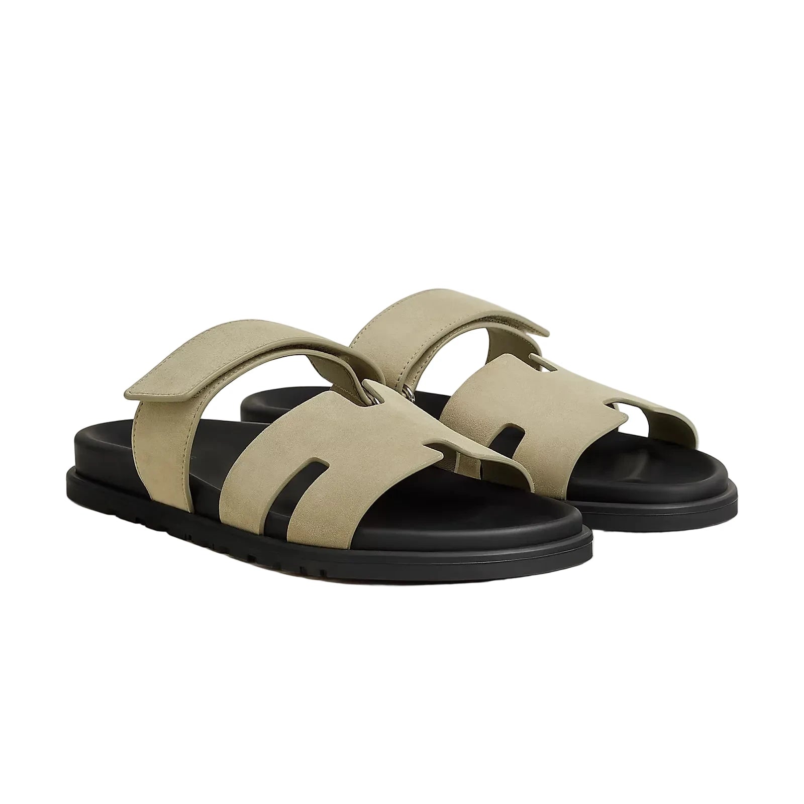Beige sandals with black soles on a light gray background