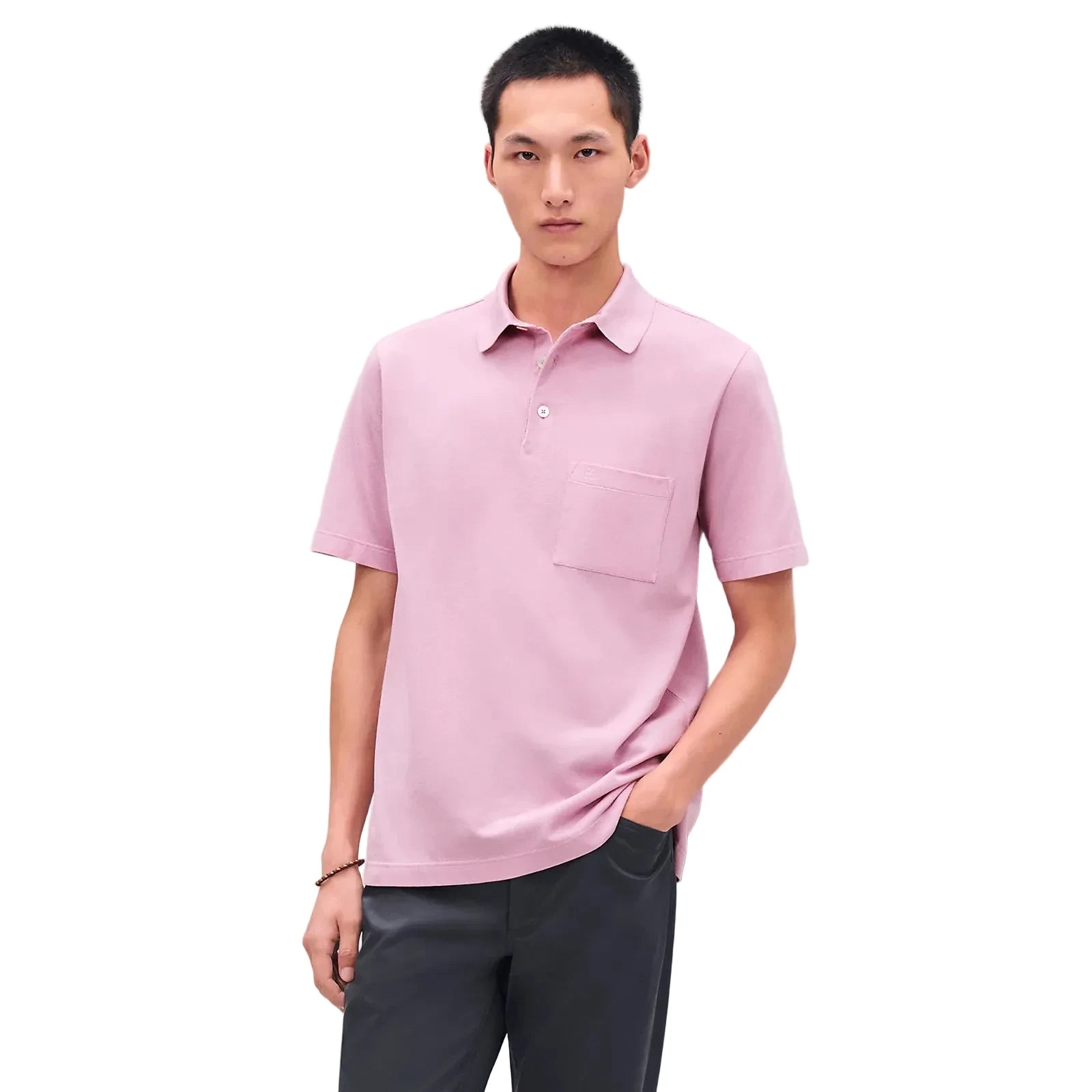 Man wearing a pink polo shirt against a light gray background