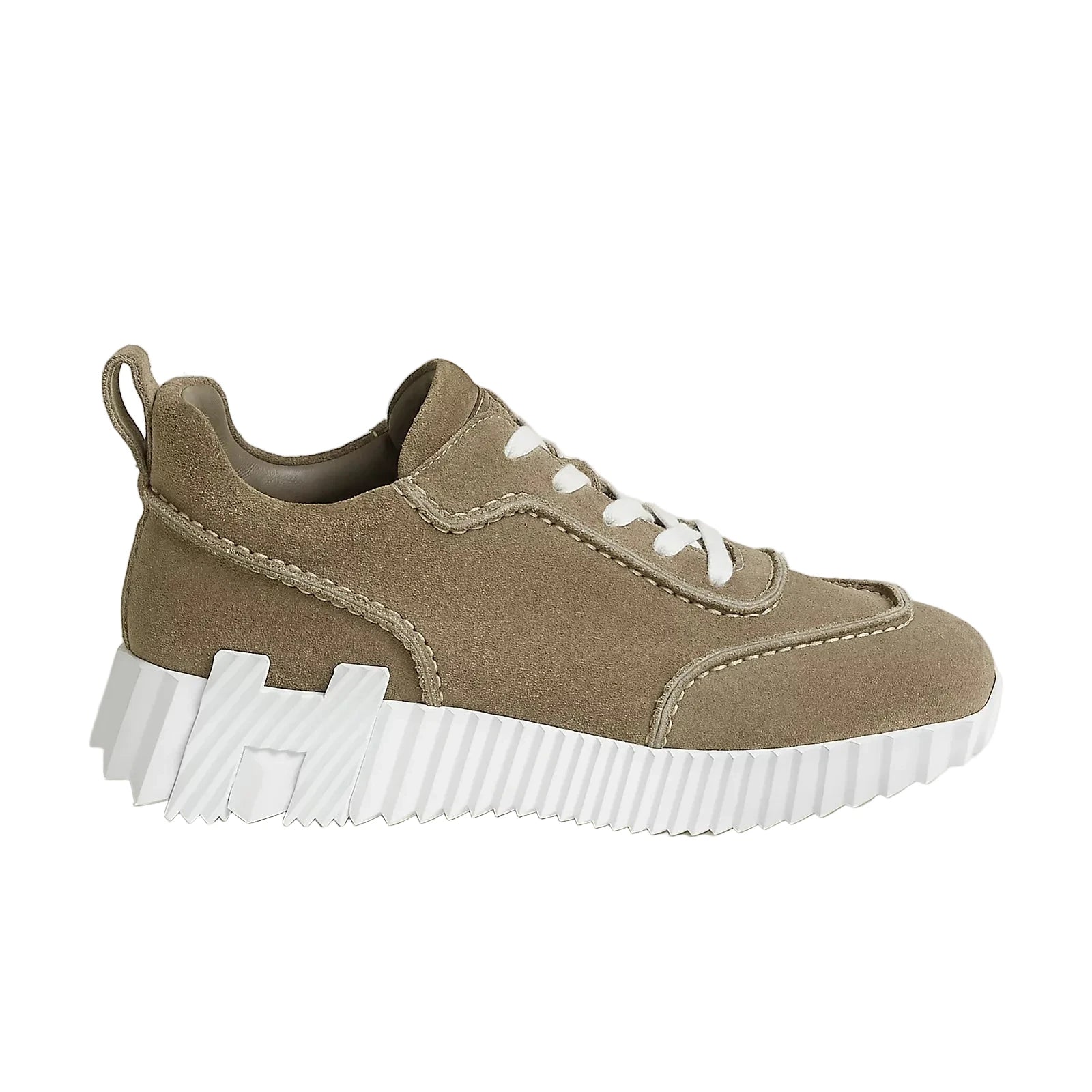 Brown sneaker with white sole on a beige background