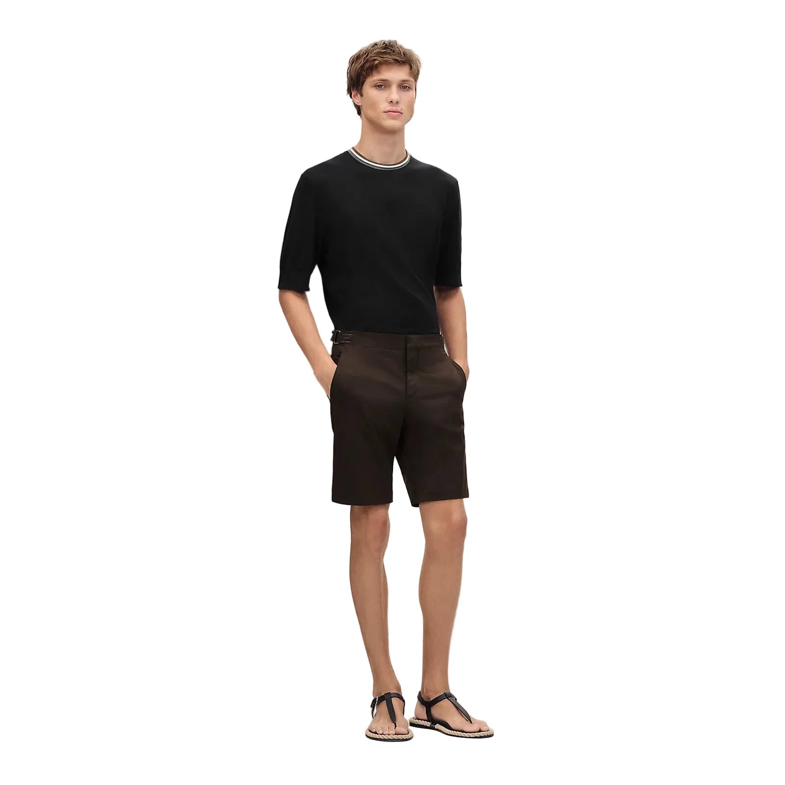 Man wearing a black t-shirt and shorts standing against a plain background