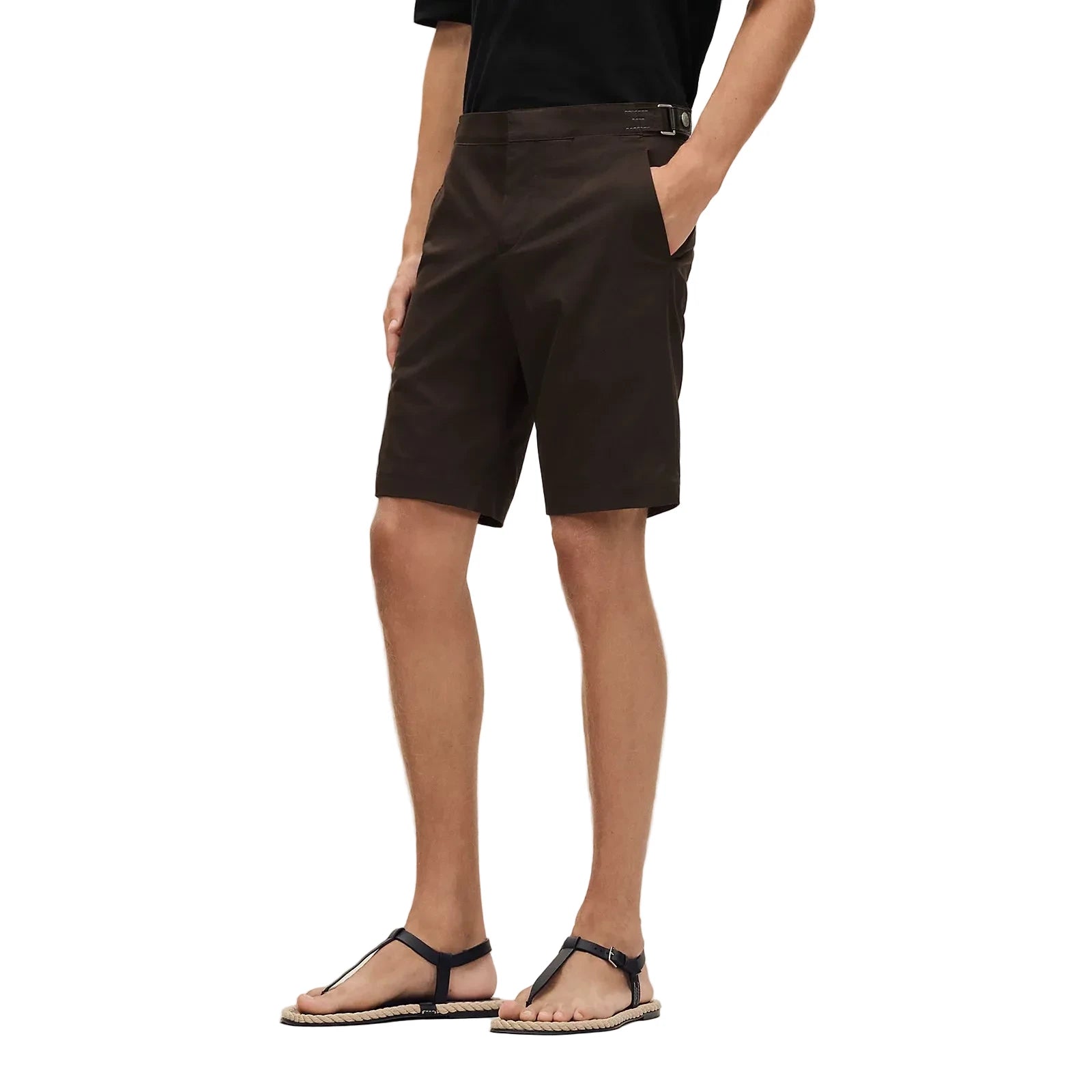 Person wearing brown shorts on a beige background