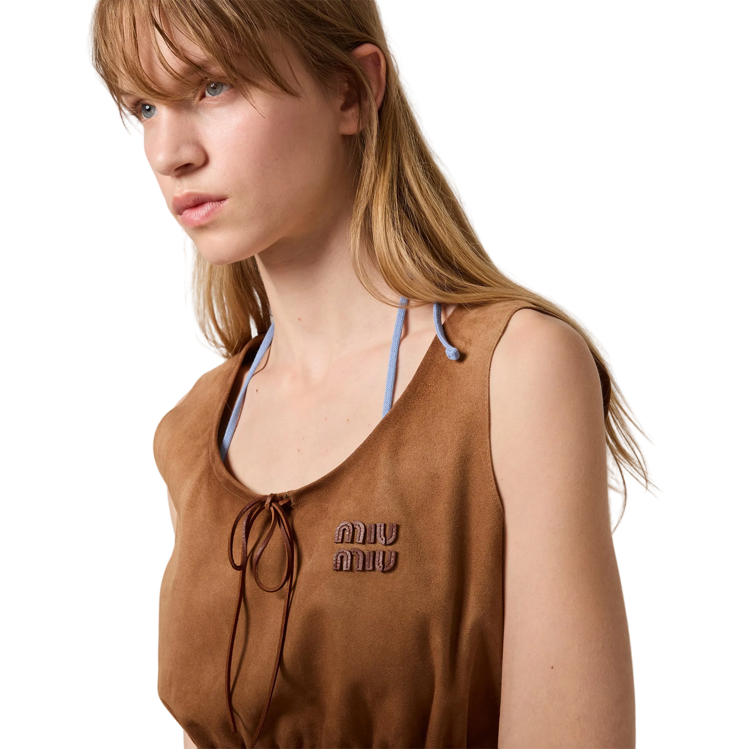 Woman wearing a brown sleeveless top with 'miu miu' logo against a plain background