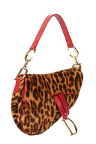 Leopard print handbag with red straps and gold hardware on a white background