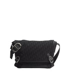 Black textured shoulder bag with silver buckles on a light gray background
