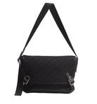 Black shoulder bag with a strap on a light gray background