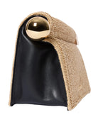 Black clutch with gold ball and woven design on a light gray background