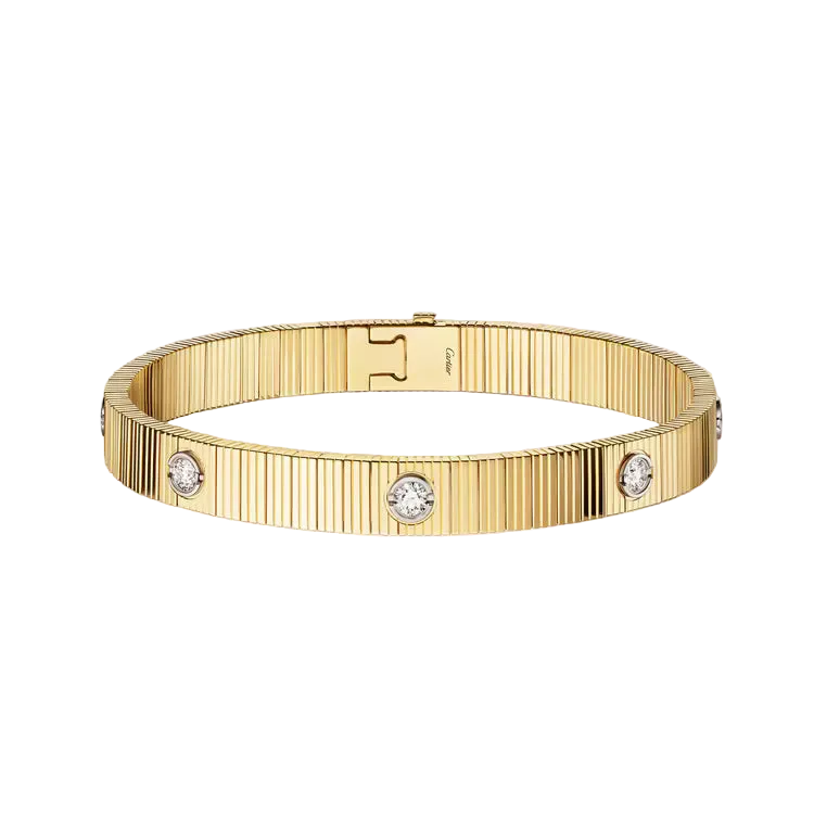 A gold-tone Cartier bracelet with three round clear gemstones, displayed on a clean off-white background. The Cartier logo is visible on the interior clasp.