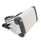 Close-up of a beige fabric bag with black straps on a white background
