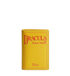 Yellow Dior wallet designed like a book cover with 'Dracula' by Bram Stoker text.