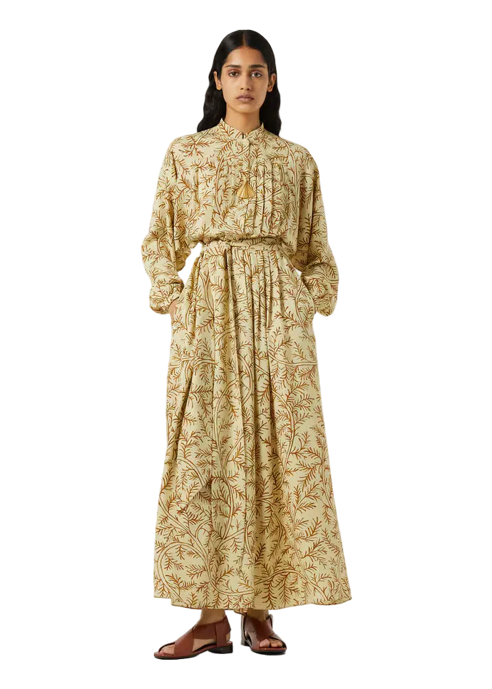 Woman wearing a long, patterned dress on a white background