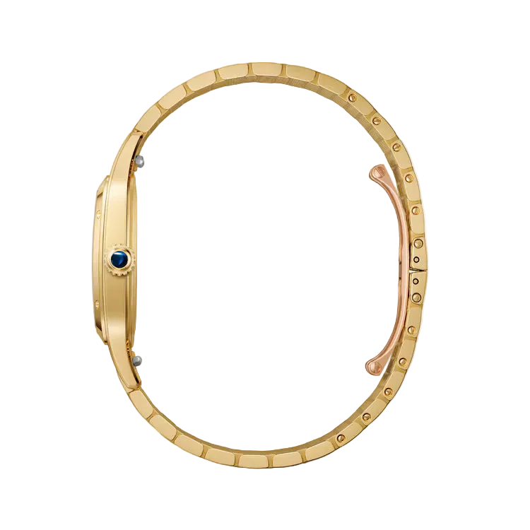 A close-up studio shot of a gold-tone watch bracelet with a blue accent gemstone on the side and a rose gold clasp, set against a clean off-white background.