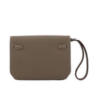 Brown leather clutch bag with a strap on a light gray background