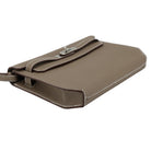 Brown leather handbag with a strap on a light gray background