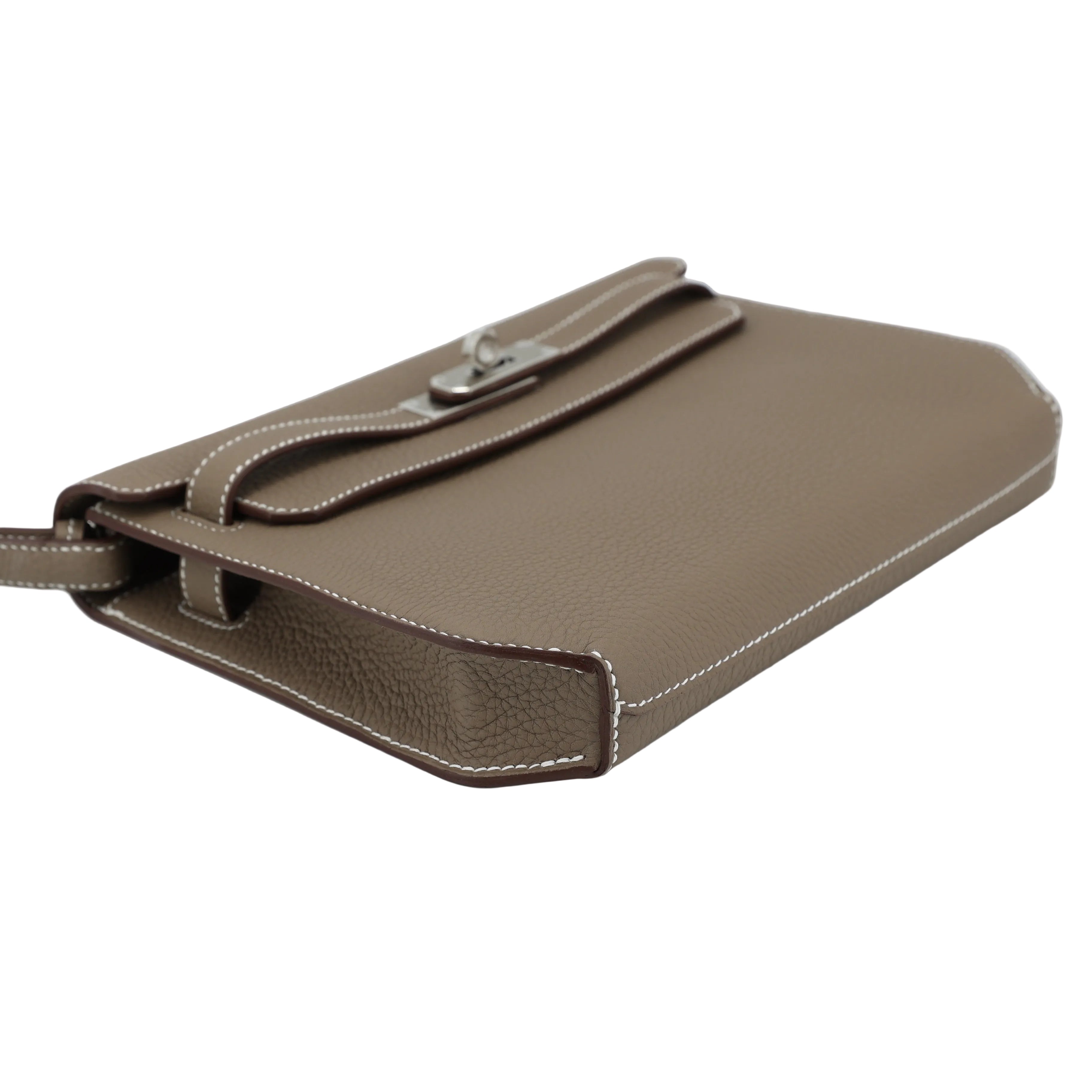 Brown leather handbag with a strap on a light gray background