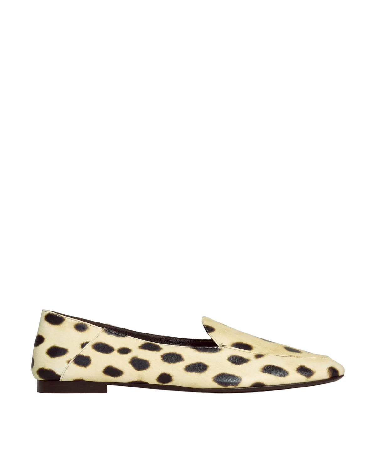 A single flat loafer shoe with a cream-colored hair-on-hide upper featuring black leopard spots, shown in a side profile against a light gray background.