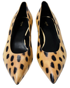 A pair of pointed-toe Celine pumps in a tan and black leopard print, photographed from a top-down angle on a light gray background.