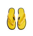 Pair of yellow flip-flops with black soles on a light gray background