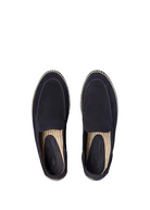 Pair of black espadrille shoes on a light beige background