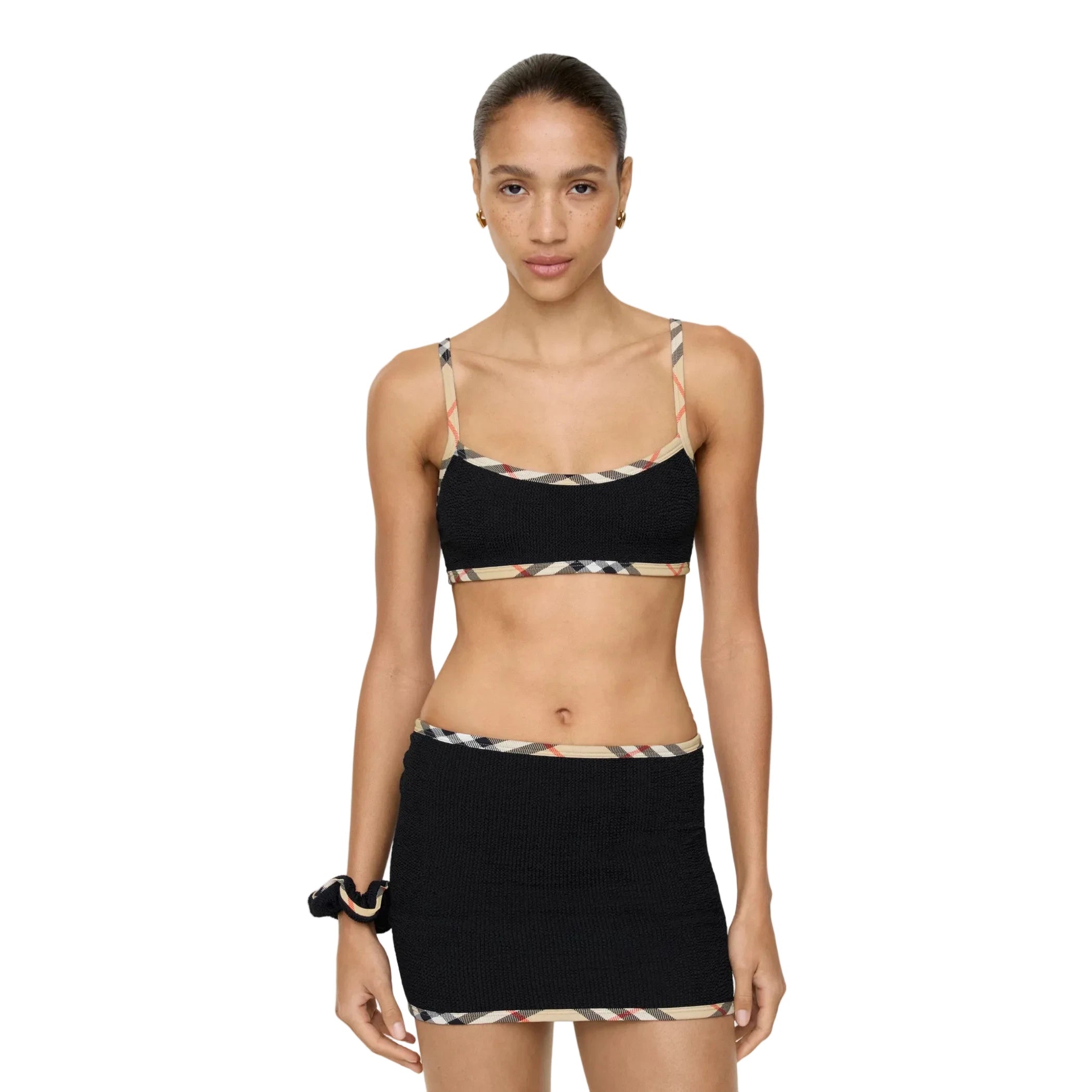 Woman wearing a black and patterned bikini set on a white background