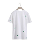 White t-shirt with green four-leaf clover patterns on a white background