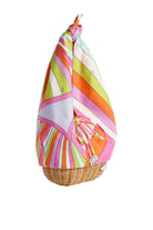 Colorful striped fabric draped over a wicker basket on a white background