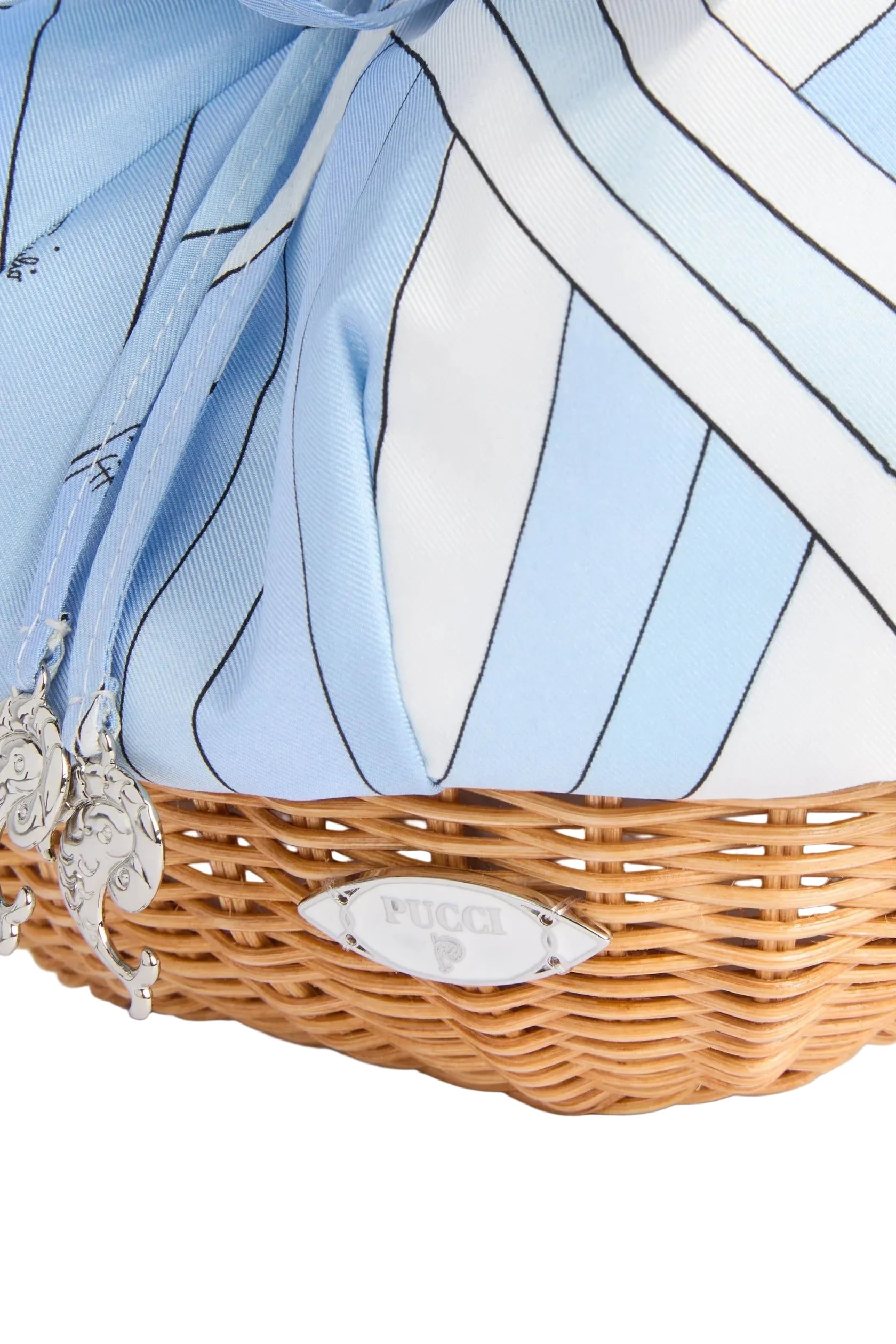 Wicker basket with decorative ribbon and decorative plate on a light background