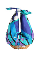 Colorful scarf tied around a wicker basket on a light gray background