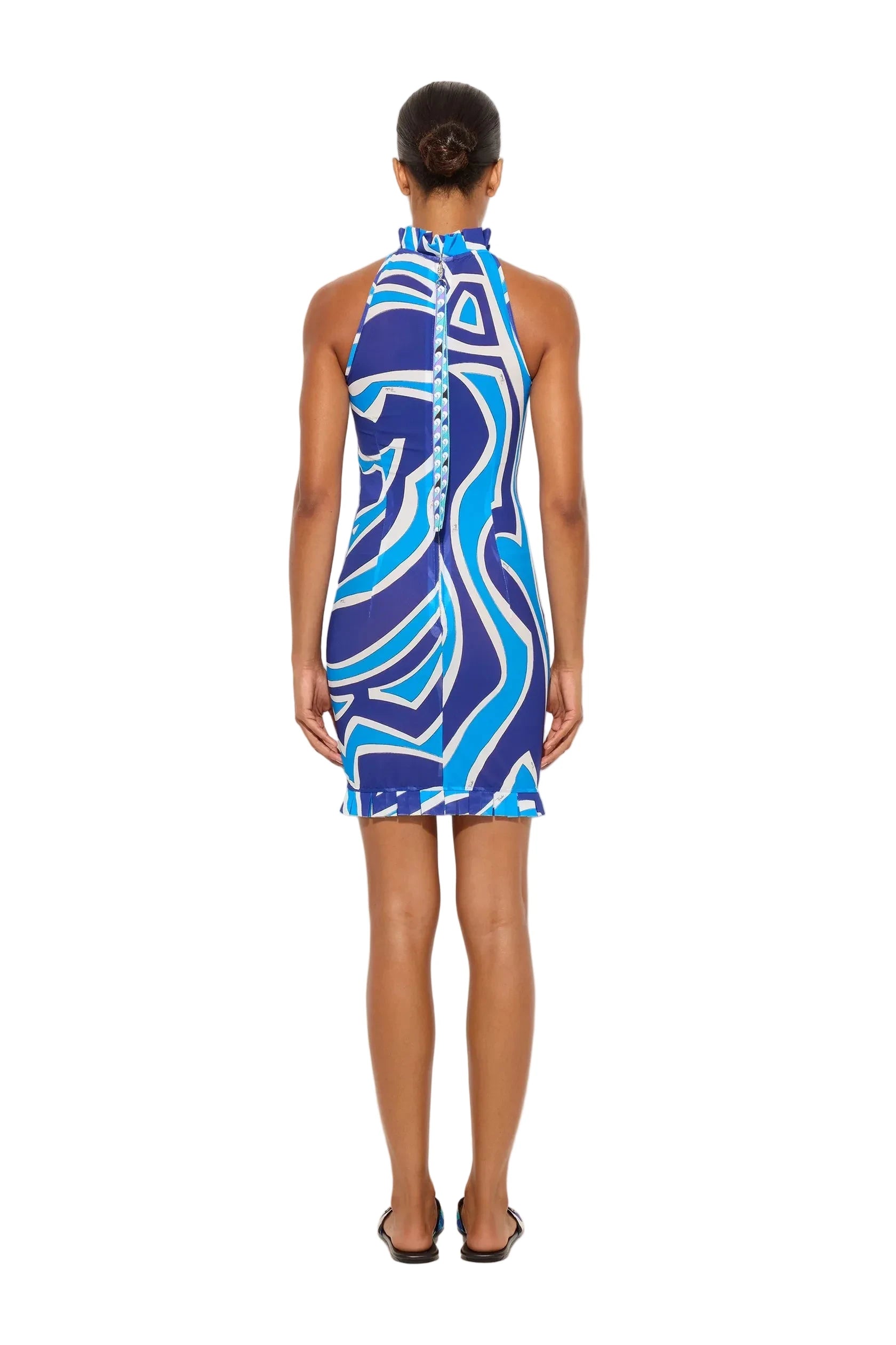 Woman wearing a blue and white patterned dress against a white background