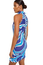 Woman wearing a blue and white patterned dress against a plain background