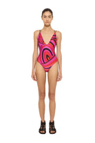 Model wearing a colorful swimsuit on a white background