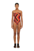 Model wearing a strapless, multicolored swimsuit with a geometric pattern on a white background