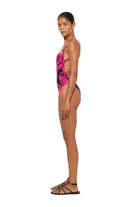 Woman wearing a pink and black patterned swimsuit on a white background