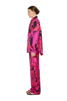 Person wearing a vibrant pink and black patterned outfit on a white background