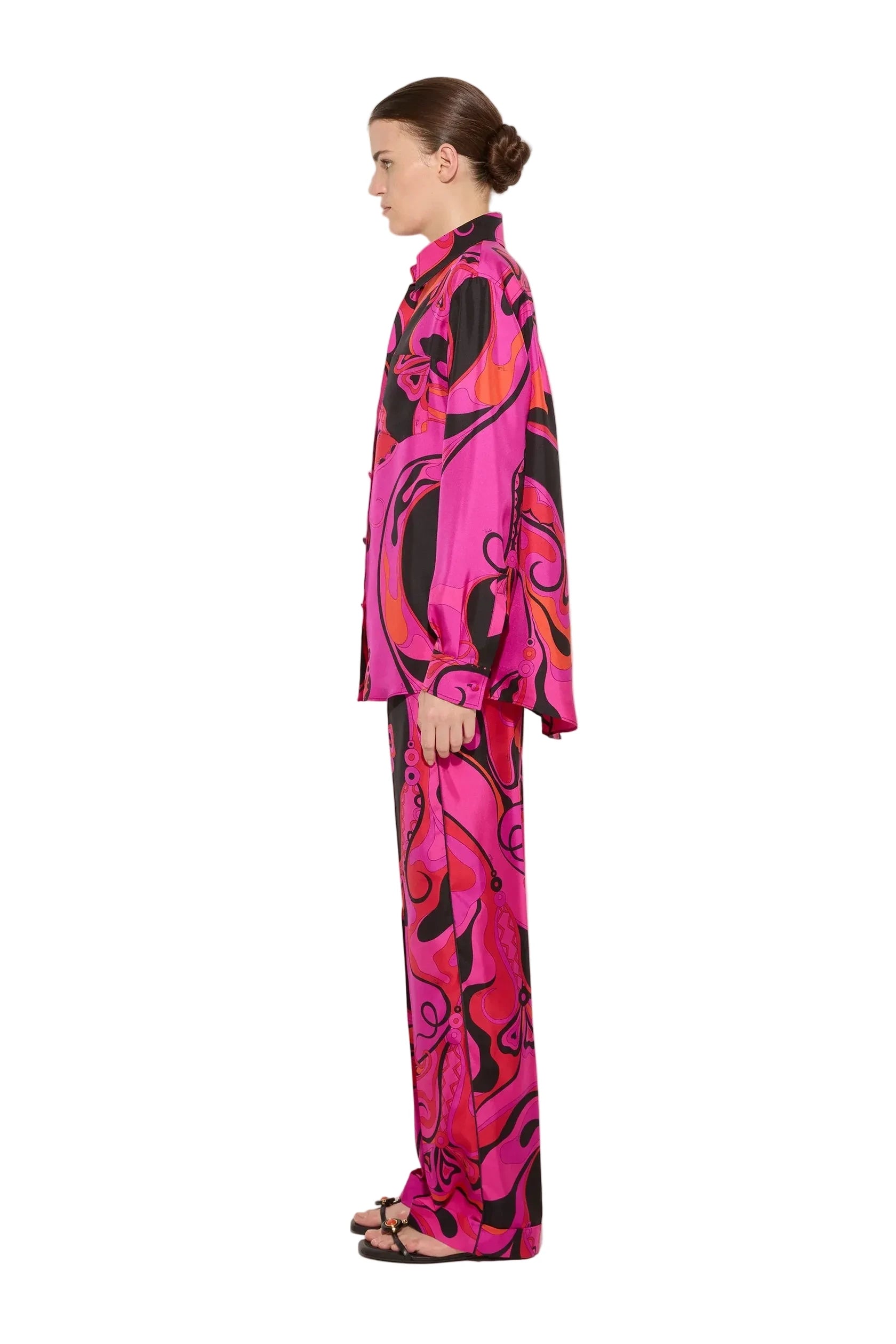 Person wearing a vibrant pink and black patterned outfit on a white background