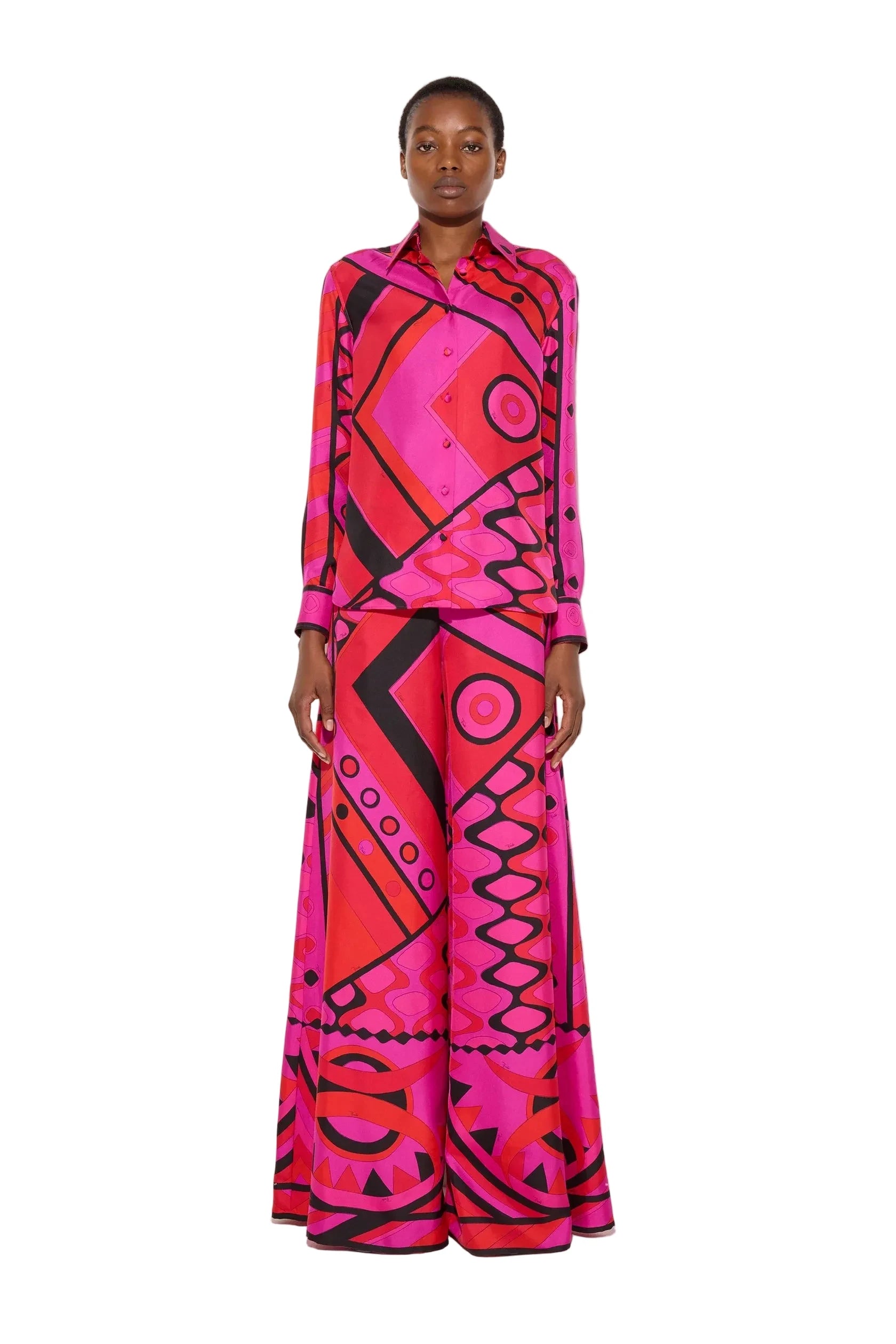 Person wearing a vibrant pink and red patterned outfit on a white background