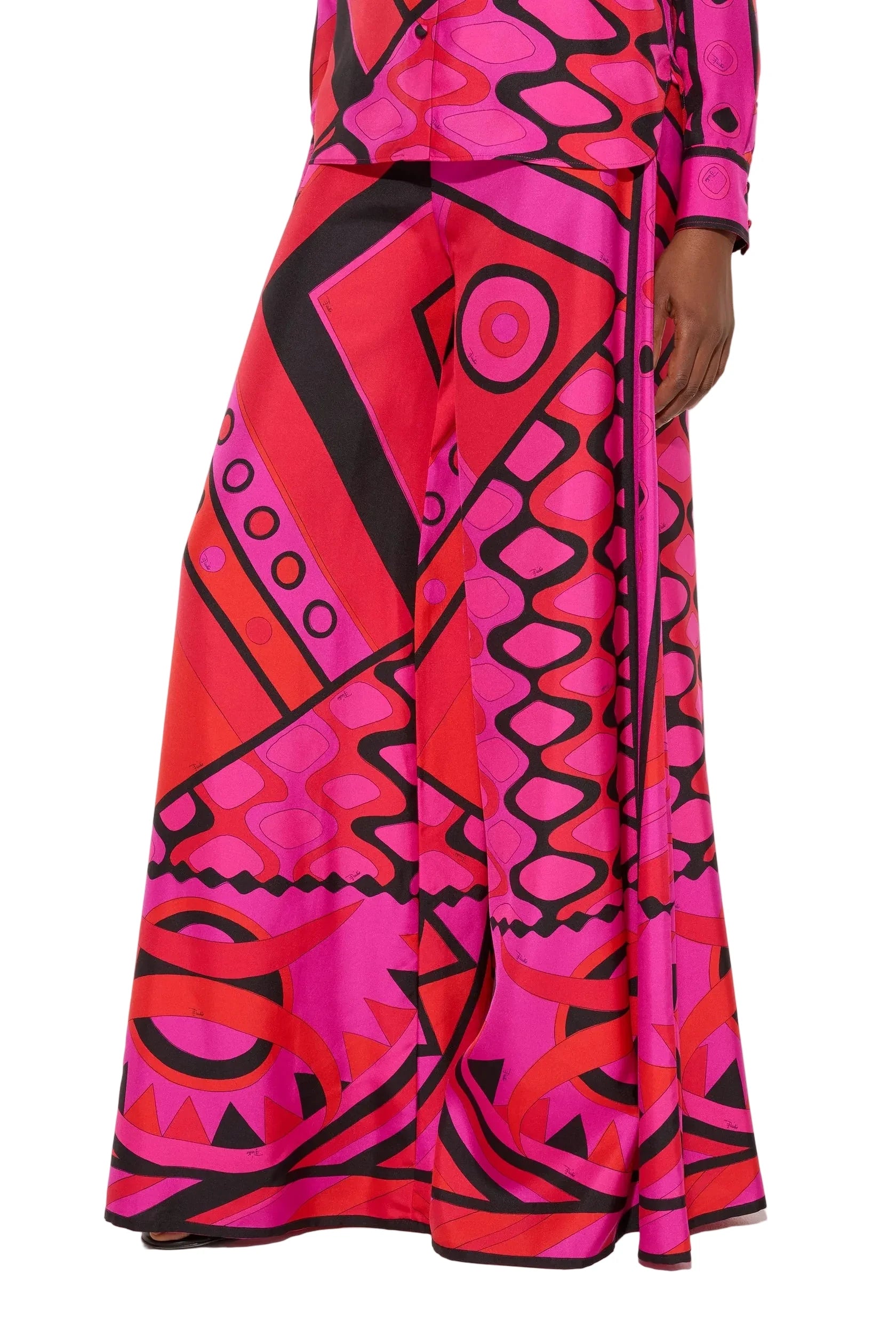 Person wearing a vibrant pink and red patterned outfit on a white background